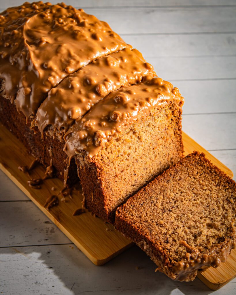 Close-up of eggless dairyfree banana bread with crisp crumble and smooth Biscoff spread glaze