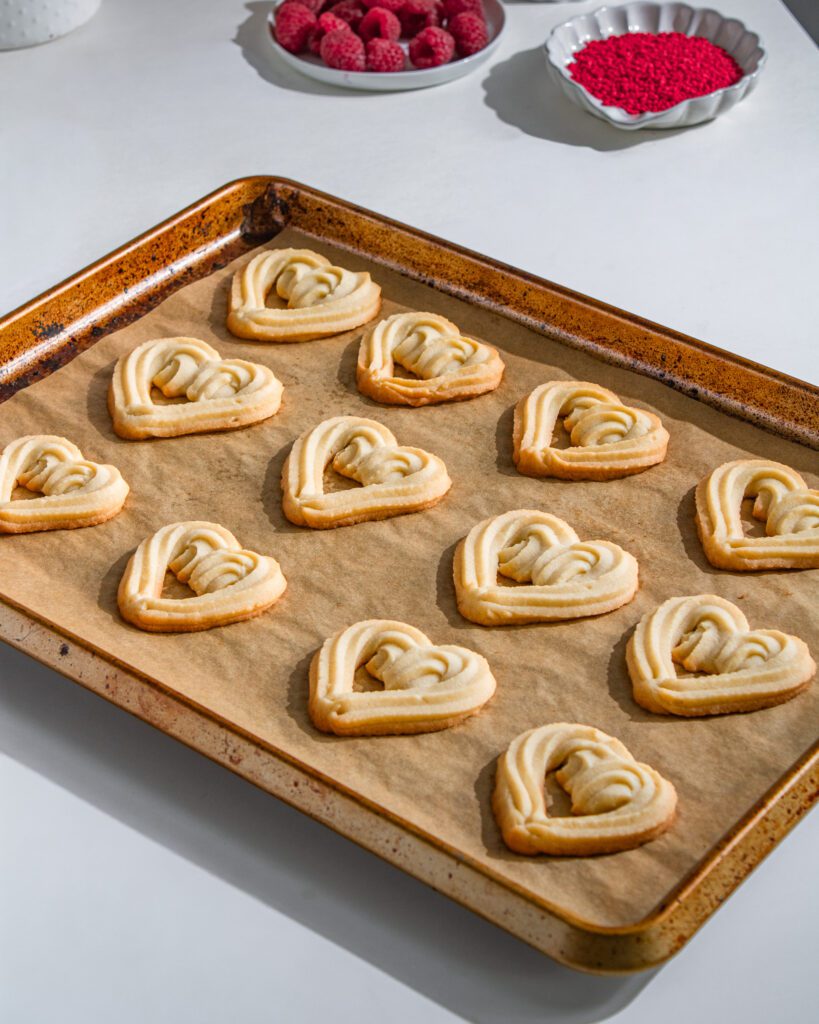 eggless Hand-piping butter cookie dough into heart shapes
