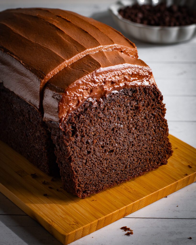 Recipe for Eggless chocolate loaf cake with cream cheese icing on a wooden board