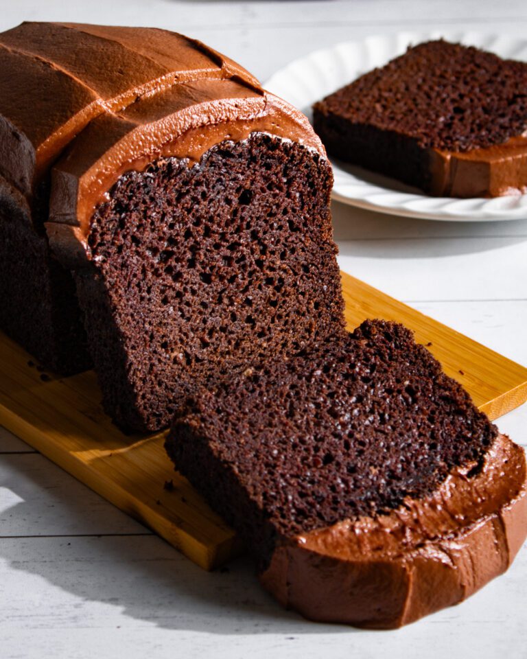 Recipe for Eggless chocolate loaf cake with cream cheese icing on a wooden board