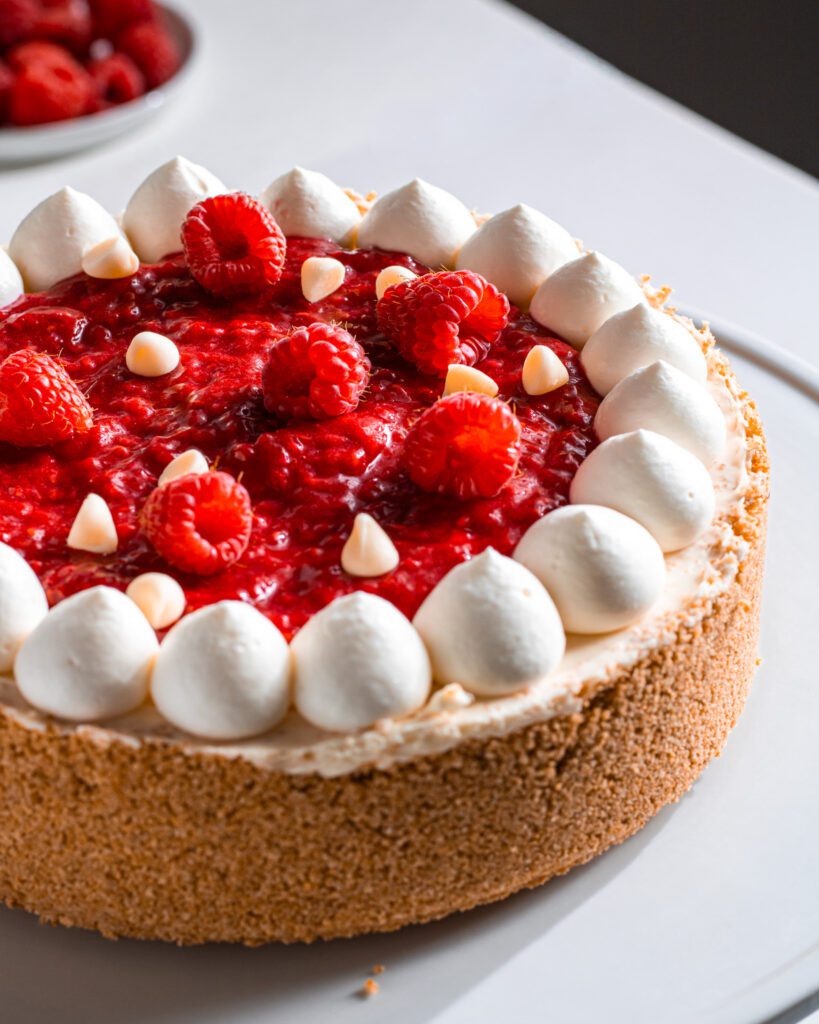 Eggless Dairy-free white chocolate cheesecake topped with fresh raspberries