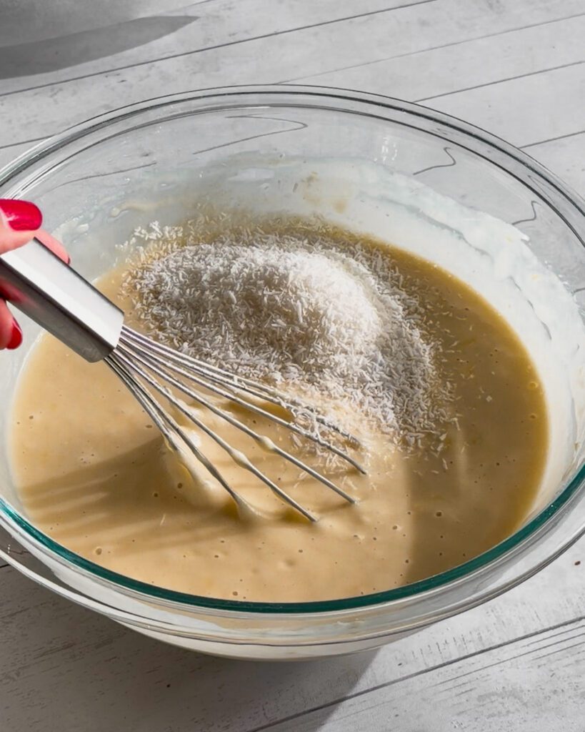 Adding shredded coconut into lemon cake batter