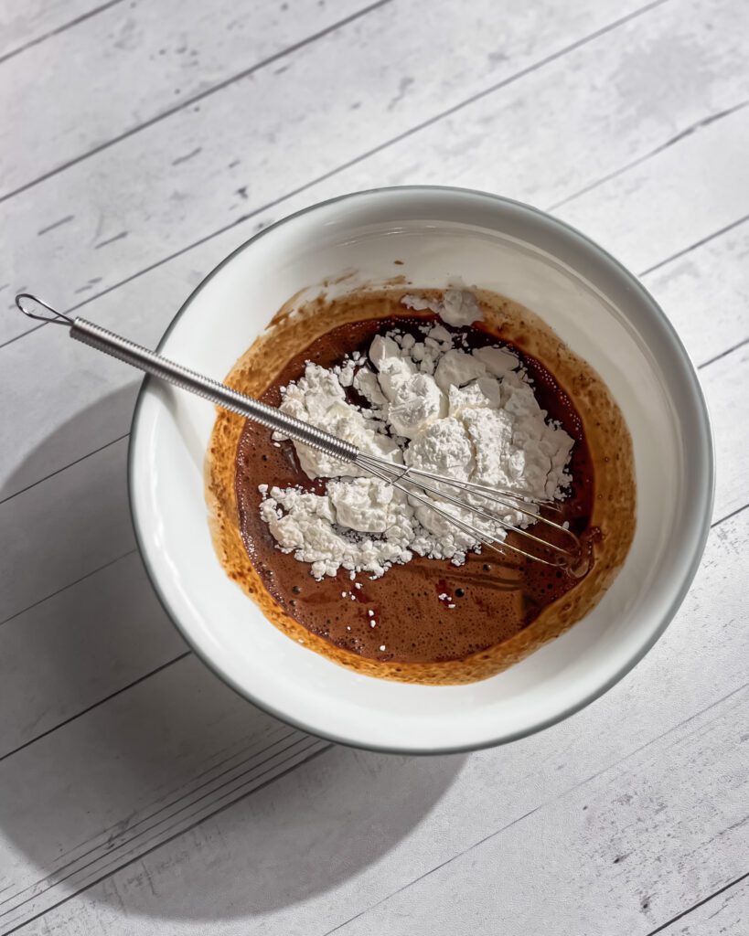 Mixing coffee glaze until smooth and glossy