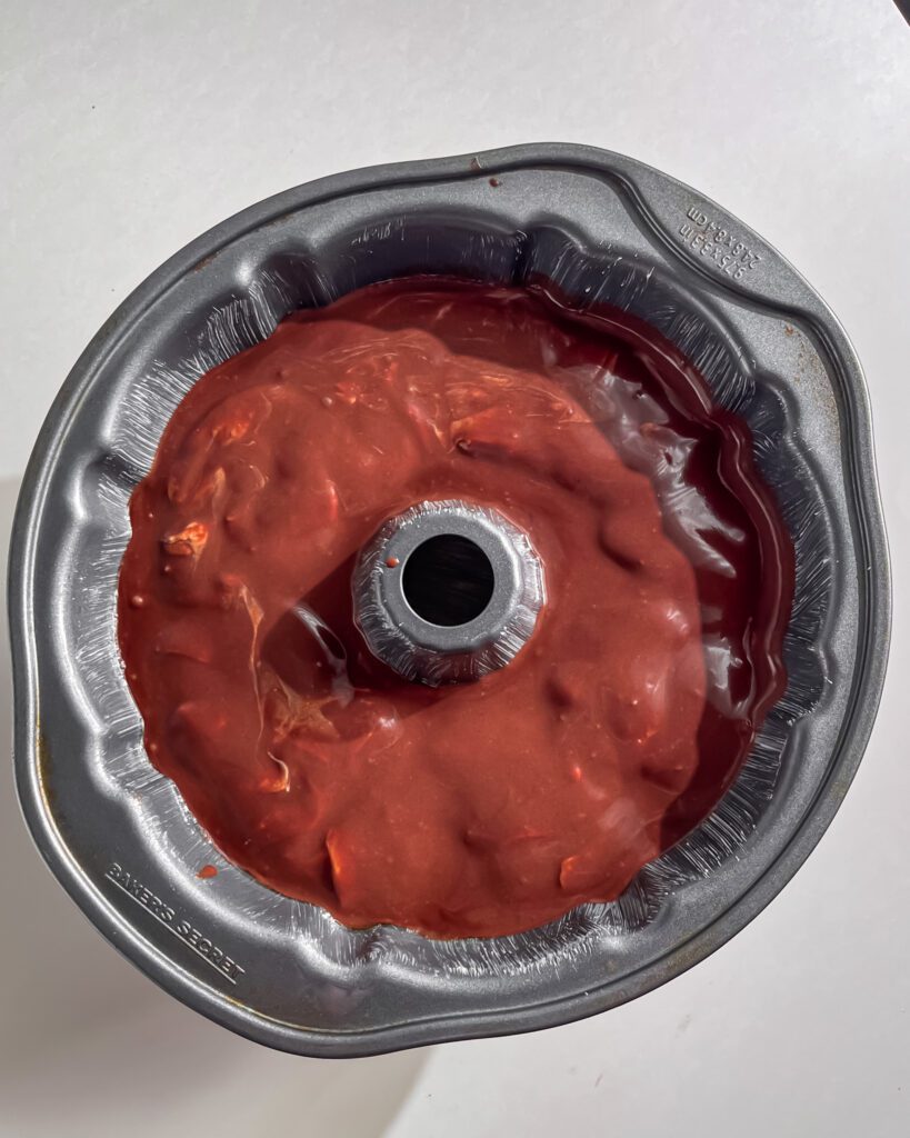 Pouring chocolate batter into greased bundt pan ready to bake