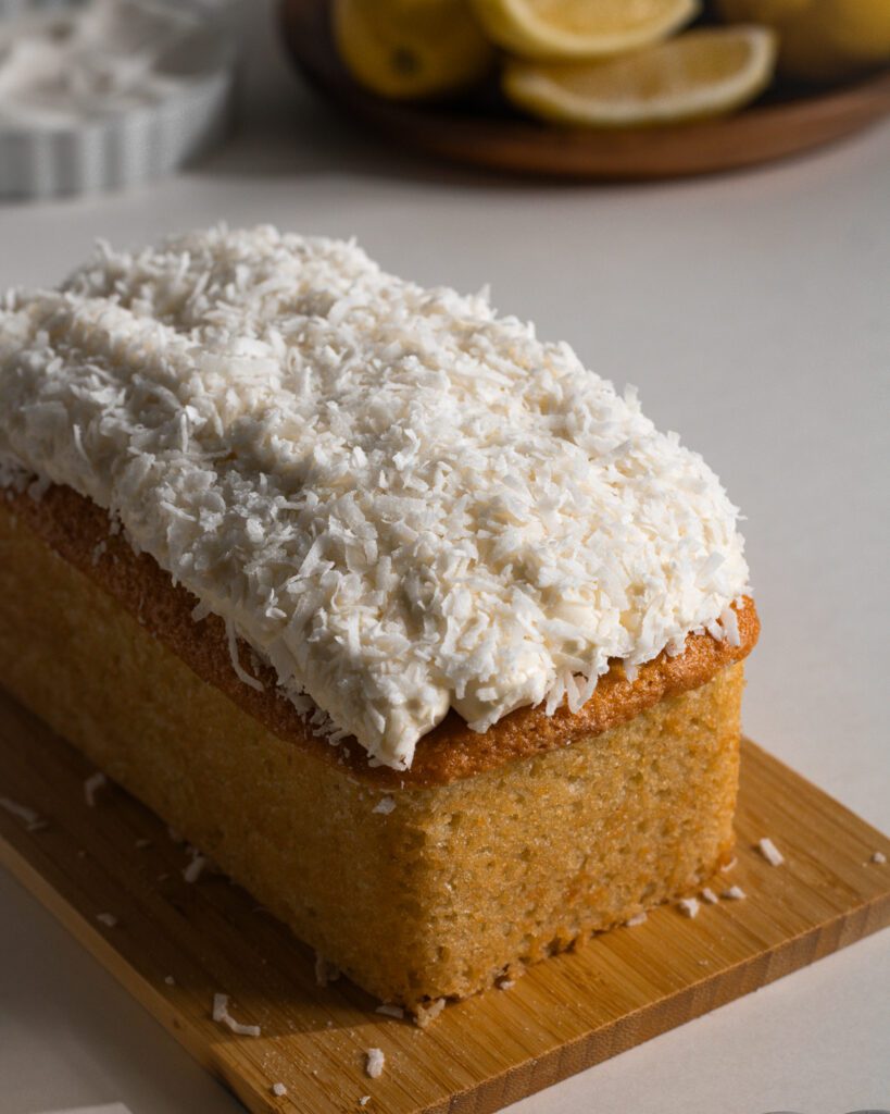 Soft lemon loaf cake topped with shredded coconut flakes